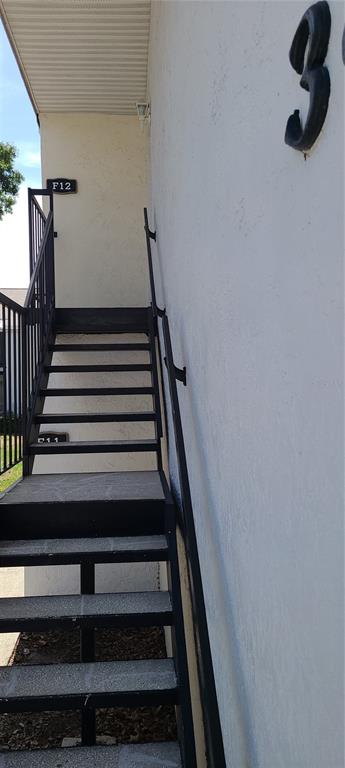 An exterior view of a metal staircase leading to an upper-level apartment entrance — 3813 N OAK DRIVE UNIT F12, TAMPA, FL