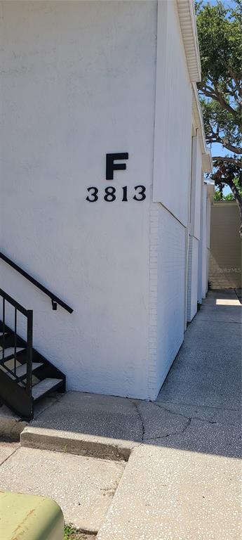 A white exterior wall features the letter F and the number 3813 above stairs — 3813 N OAK DRIVE UNIT F12, TAMPA, FL