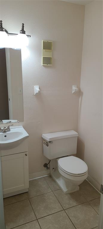 A small bathroom features a white pedestal vanity, a toilet, and a wall-mounted vent — 3813 N OAK DRIVE UNIT F12, TAMPA, FL
