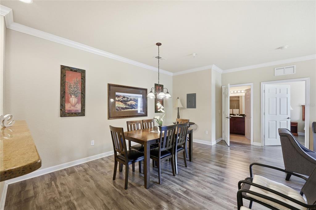 A dining area features a wooden table, six chairs, and wood-look flooring — 8020 TUSCANY WAY UNIT 6206, DAVENPORT, FL