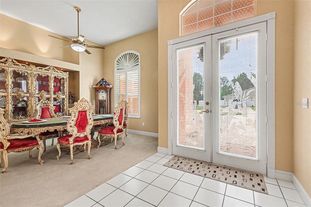 A dining room with ornate red chairs, a large hutch, and double glass entry doors — 72 WHITE STAR DRIVE, PALM COAST, FL