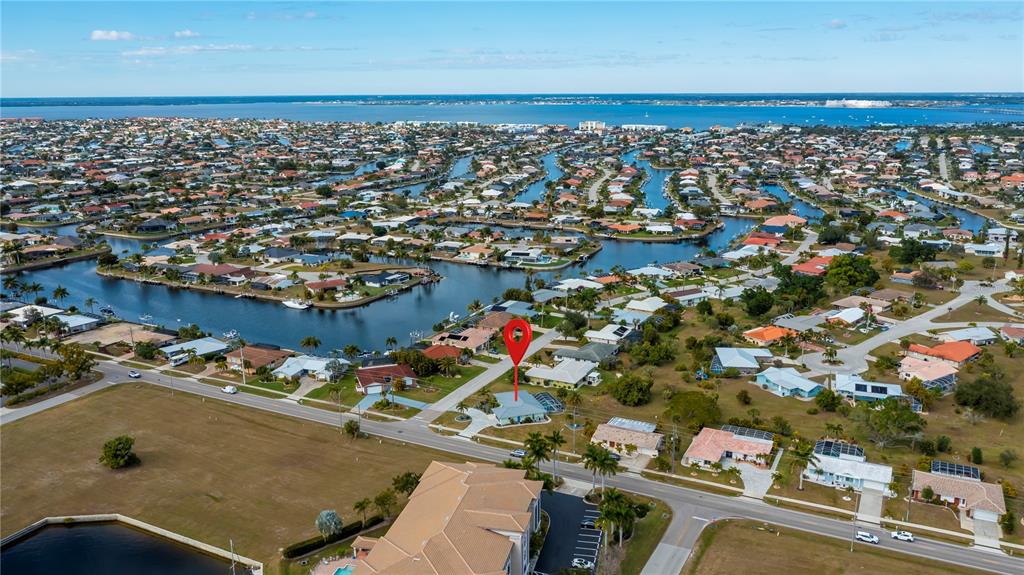 An aerial view shows a residential neighborhood with canals and a house marked by a pin — 1354 AQUI ESTA DRIVE, PUNTA GORDA, FL