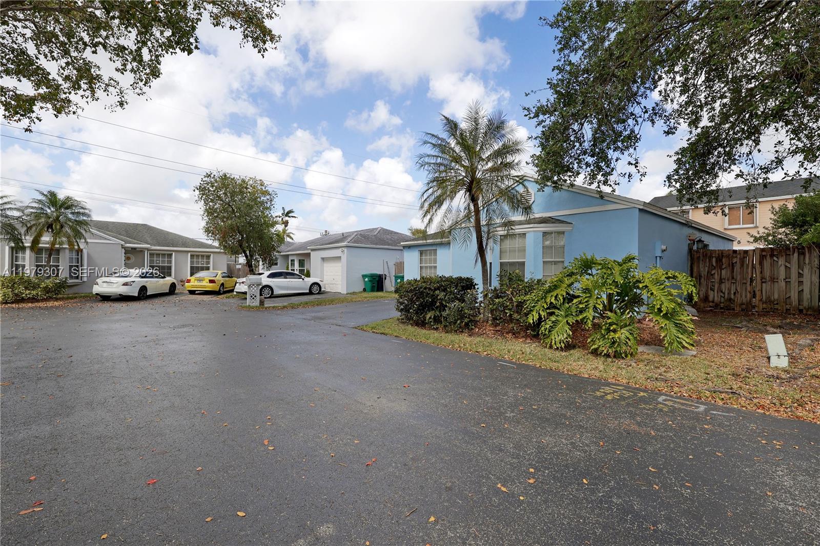 A blue house with a palm tree and parked cars sits on an asphalt lot — 14566 SW 124th Pl, Miami FL 33186, MIAMI, FL