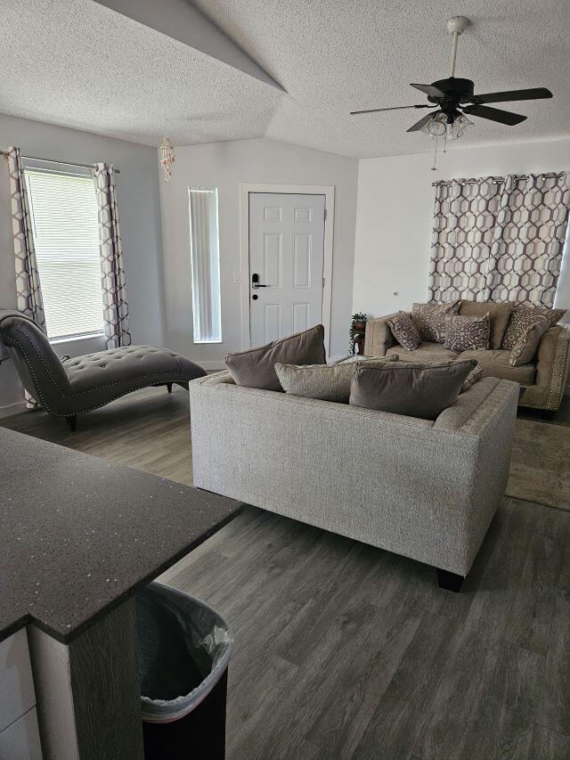 A living room features gray flooring, a sofa, a chaise lounge, and a ceiling fan — 2812 Stoneway Lane Unit B, Fort Pierce FL 34982, FORT PIERCE, FL