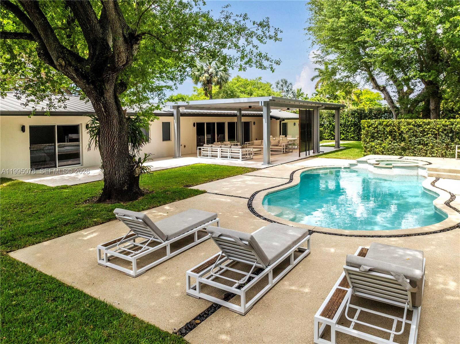 A backyard features a swimming pool, lounge chairs, and a covered patio area — 8525 SW 54th Ct, Miami FL 33143, MIAMI, FL