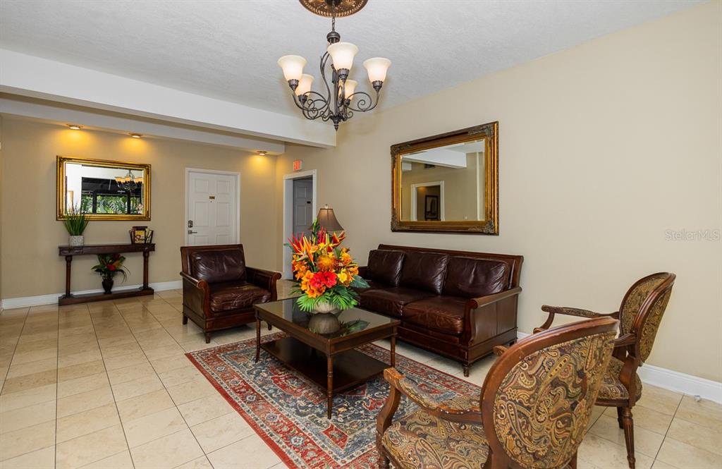 A furnished lobby features a leather sofa, armchairs, a patterned rug, and a chandelier — 2109 BAYSHORE BOULEVARD UNIT 606, TAMPA, FL