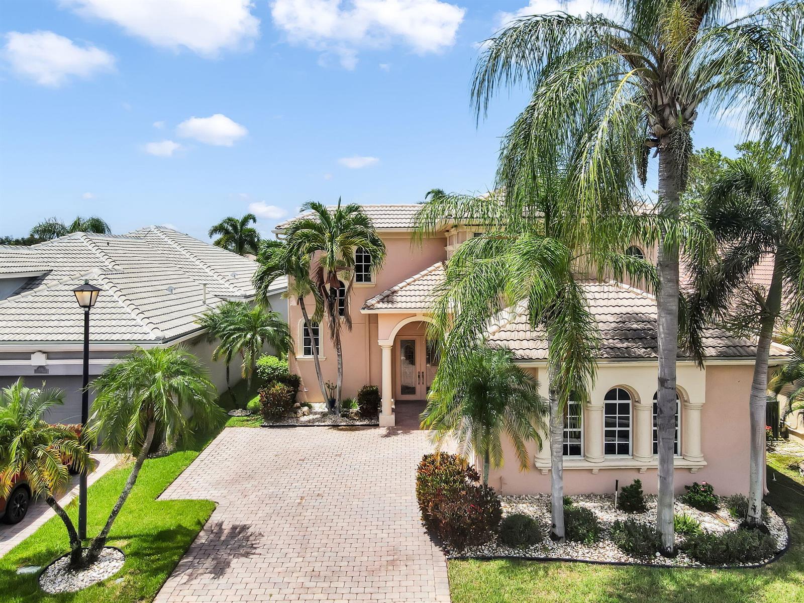 A two-story peach-colored house with a paved driveway and palm trees in the front yard — 7049 Veneto Drive, Boynton Beach FL 33437, BOYNTON BEACH, FL