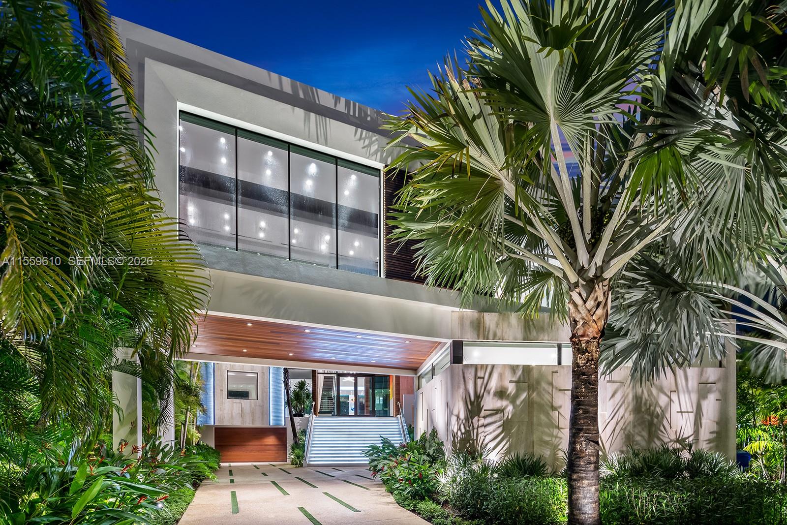 A modern two-story house exterior features a covered entryway with stairs and lush tropical landscaping — 1133 Belle Meade Island Dr, Miami FL 33138, MIAMI, FL