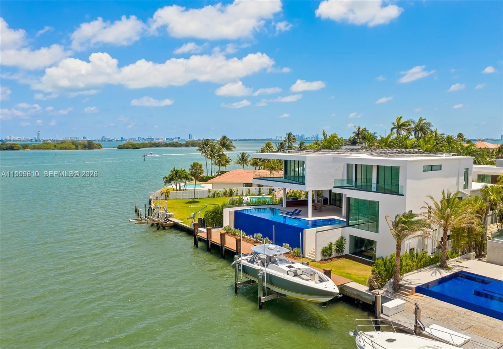 A modern waterfront house features a swimming pool, a boat lift, and a private dock — 1133 Belle Meade Island Dr, Miami FL 33138, MIAMI, FL