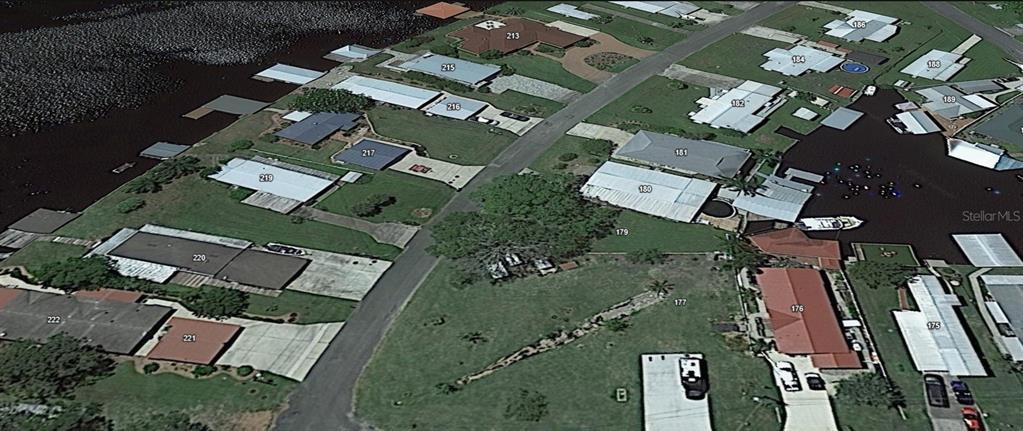 This aerial view shows a residential neighborhood with houses situated along a canal — 179 SPORTSMAN DRIVE, WELAKA, FL