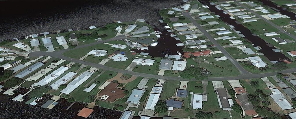 This aerial view shows a waterfront residential neighborhood with mobile homes and private boat docks — 179 SPORTSMAN DRIVE, WELAKA, FL