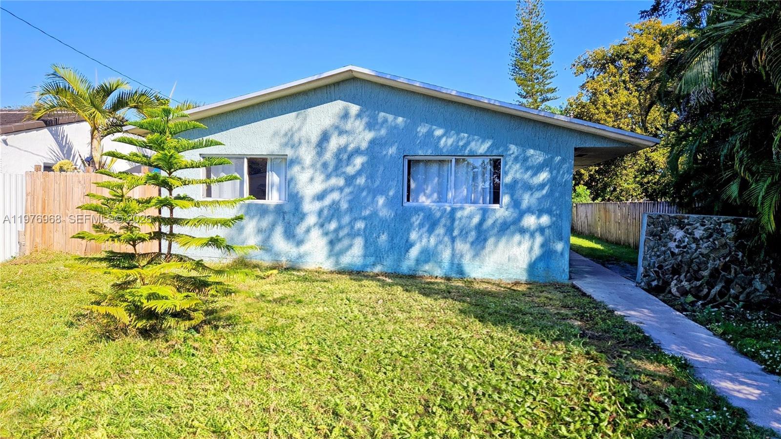 A light blue, single-story house with two windows and a concrete walkway — 2411 Thomas St, Hollywood FL 33020, HOLLYWOOD, FL