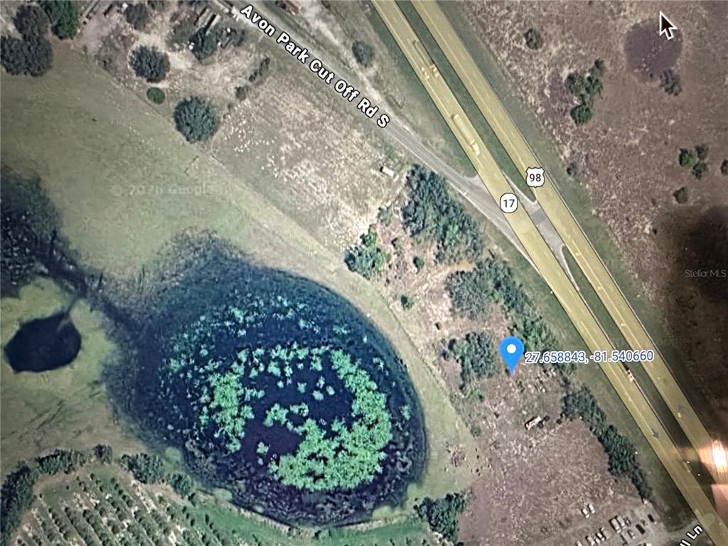 This is an aerial map view showing a pond, a highway, and a vacant lot — 0 US HIGHWAY 27, FROSTPROOF, FL