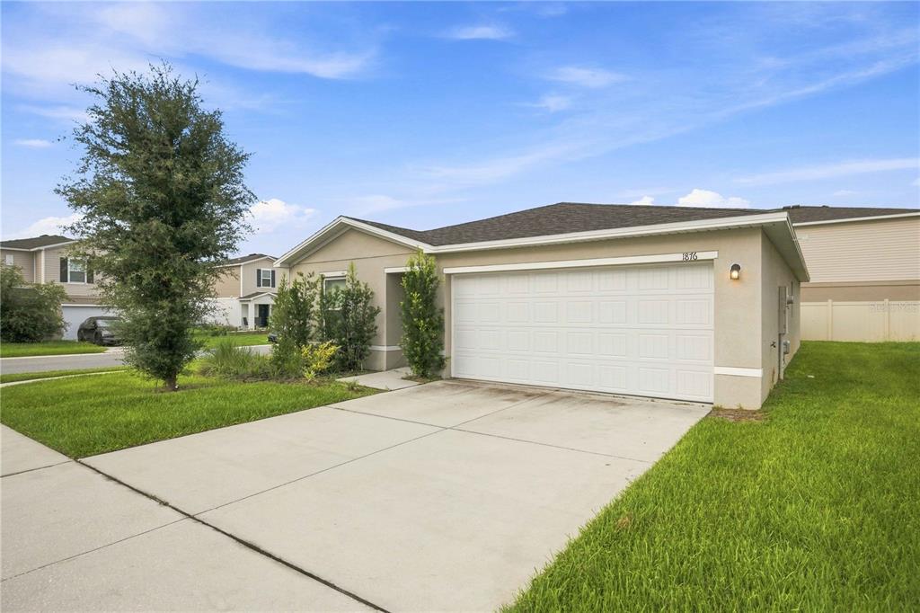 A single-story suburban house with a two-car garage and a concrete driveway — 1876 IOWA DRIVE, SUMTERVILLE, FL