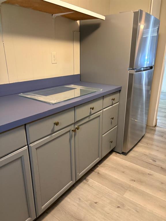 A kitchen features gray cabinets, a blue countertop, and a stainless steel refrigerator — 1616 TERRY ROAD, LAKELAND, FL
