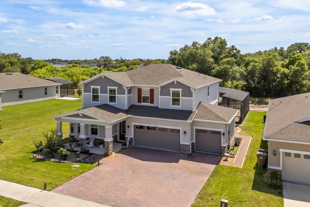 An aerial view of a two-story house with a paved driveway and a three-car garage — 10260 SPRING LAKE DRIVE, CLERMONT, FL