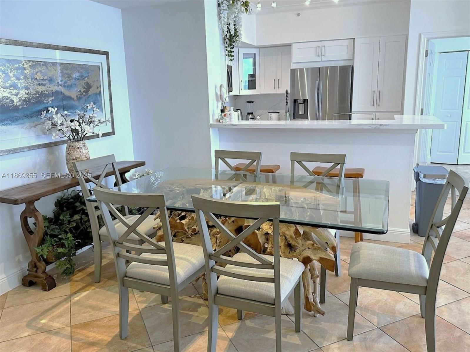A dining area features a glass-topped table with a driftwood base and light-colored chairs — 2080 S OCEAN DRIVE, Hallandale Beach FL 33009, HALLANDALE BEACH, FL