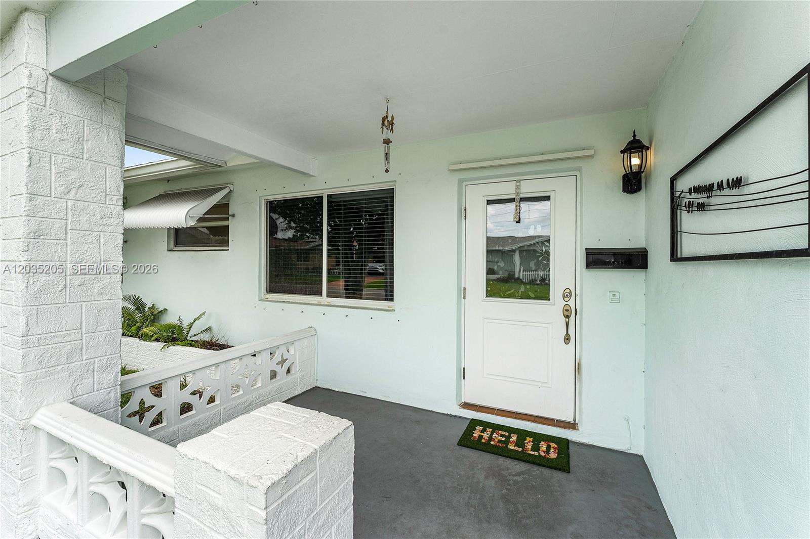 A light green exterior porch features a white front door, a window, and a railing — 4705 NW 43rd Ave, Tamarac FL 33319, TAMARAC, FL
