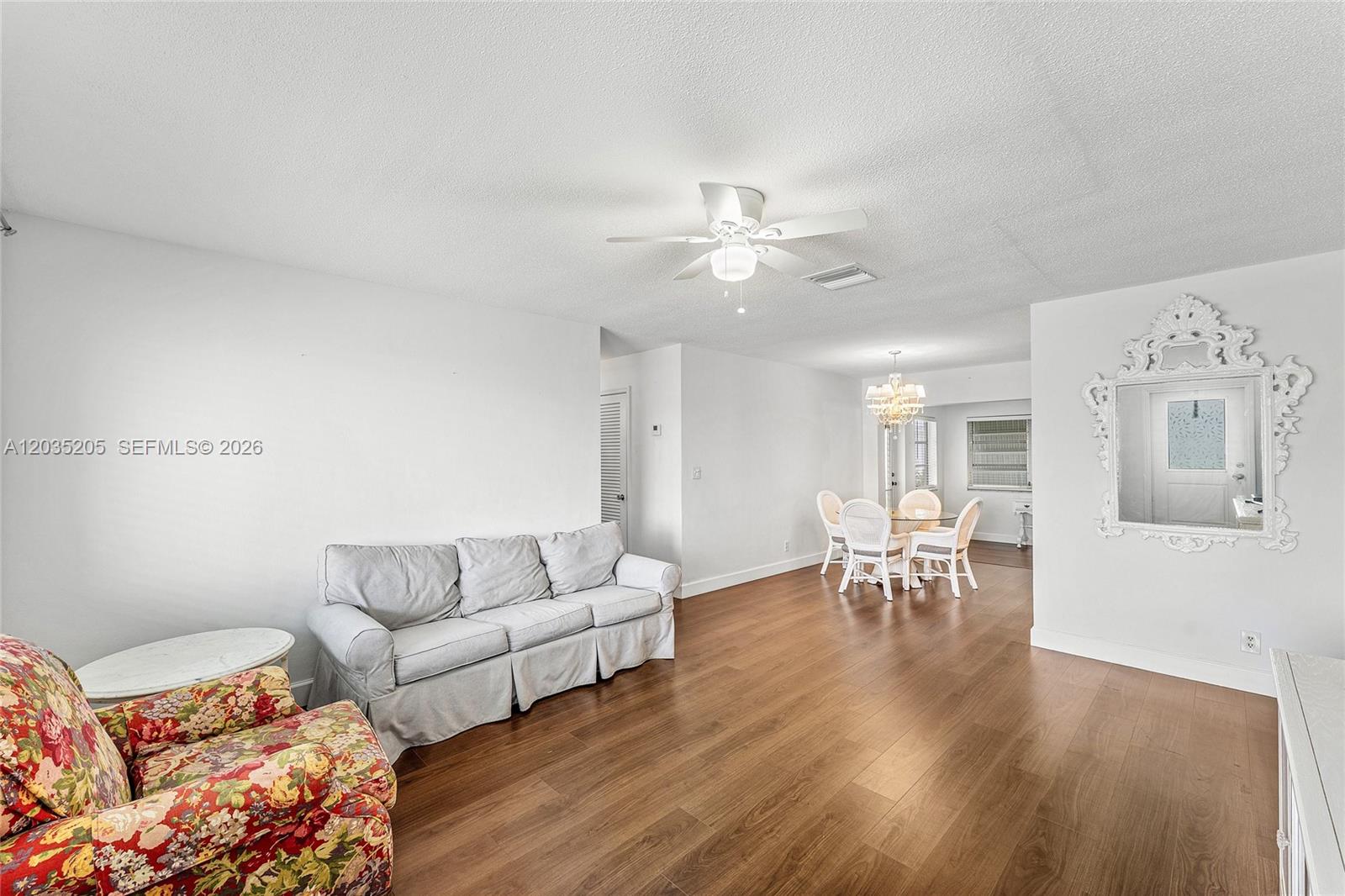 A living and dining area features white walls, wood-look flooring, and a ceiling fan — 4705 NW 43rd Ave, Tamarac FL 33319, TAMARAC, FL