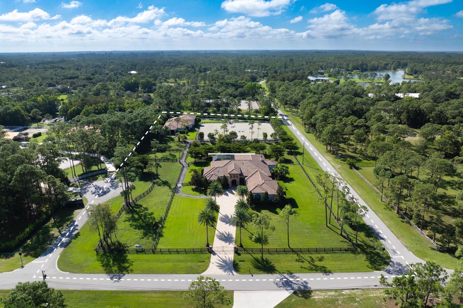 An aerial view of a residential estate featuring a house, stables, and a riding arena — 11780 Otter Run, Lake Worth FL 33449, LAKE WORTH, FL