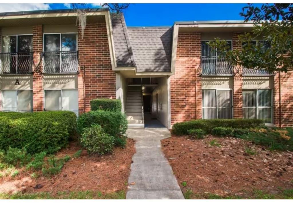 A two-story brick apartment building with a central staircase and second-floor balconies — 1700 SW 16TH COURT UNIT A5, GAINESVILLE, FL
