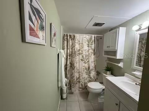 A bathroom features a vanity with a sink, a toilet, and a shower with a curtain — 1700 SW 16TH COURT UNIT A5, GAINESVILLE, FL