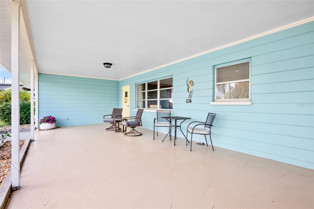 A covered patio features light blue horizontal siding, a beige floor, and outdoor furniture — 223 ROBERTS ROAD, NOKOMIS, FL