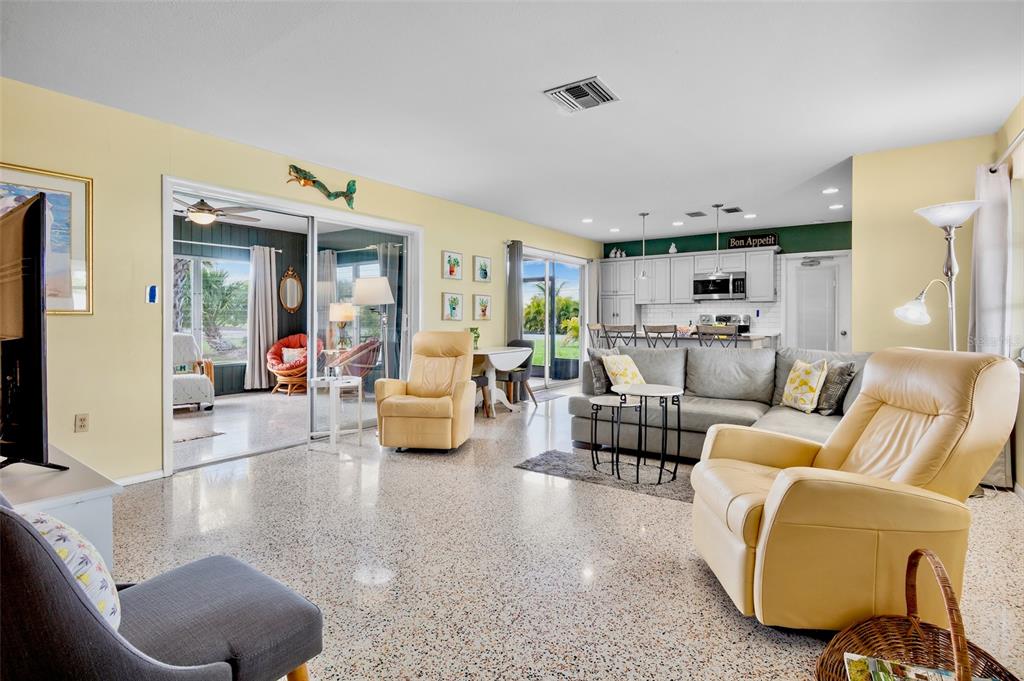 A living room with light yellow walls, terrazzo flooring, and an open-concept kitchen — 223 ROBERTS ROAD, NOKOMIS, FL
