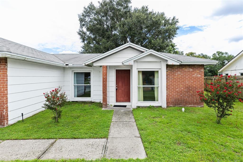 A single-story house with white siding, a red brick facade, and a red front door — 629 STILLVIEW CIRCLE, BRANDON, FL