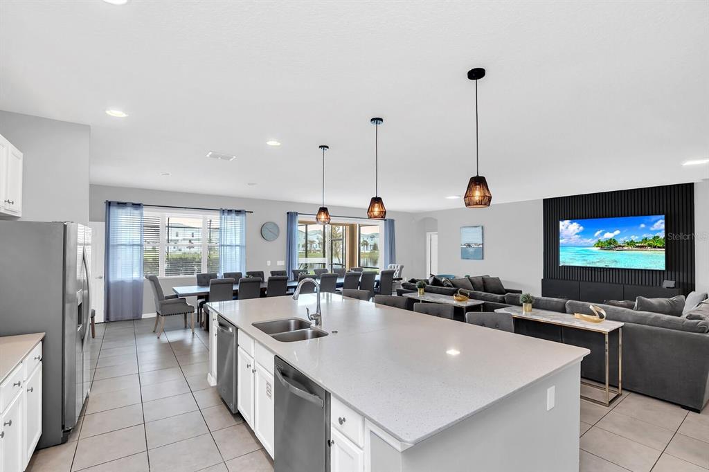A kitchen island with a sink sits in front of an open-concept living and dining area — 6148 BROAD OAK DRIVE, DAVENPORT, FL
