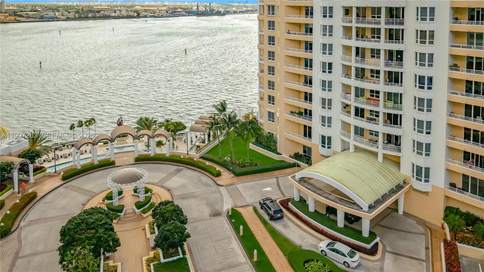 An aerial view shows a high-rise building entrance with a circular driveway and waterfront — 808 Brickell Key Dr # 2002, Miami FL 33131, MIAMI, FL