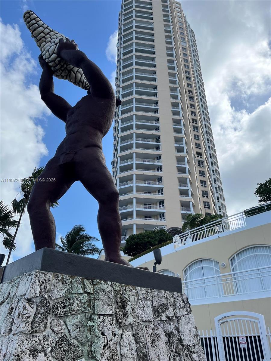 A large bronze statue of a man holding a corn cob stands before a tall skyscraper — 808 Brickell Key Dr # 2002, Miami FL 33131, MIAMI, FL
