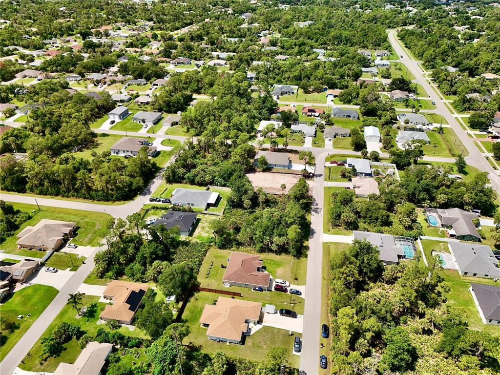 An aerial view shows a suburban neighborhood with houses, green trees, and paved roads — NANTUCKET TERRACE, NORTH PORT, FL