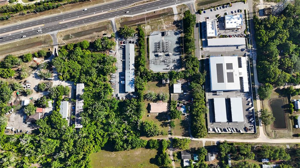 This aerial view shows a commercial property complex with warehouses, a substation, and parking areas — 13203 BLISSFIELD, ODESSA, FL