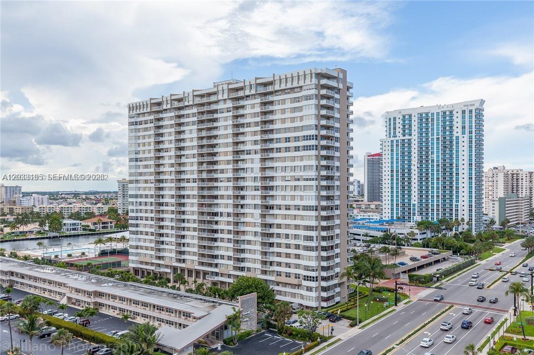 An exterior view of a tall residential high-rise building with balconies and adjacent parking lots — 2030 S Ocean Dr # 1706, Hallandale Beach FL 33009, HALLANDALE BEACH, FL
