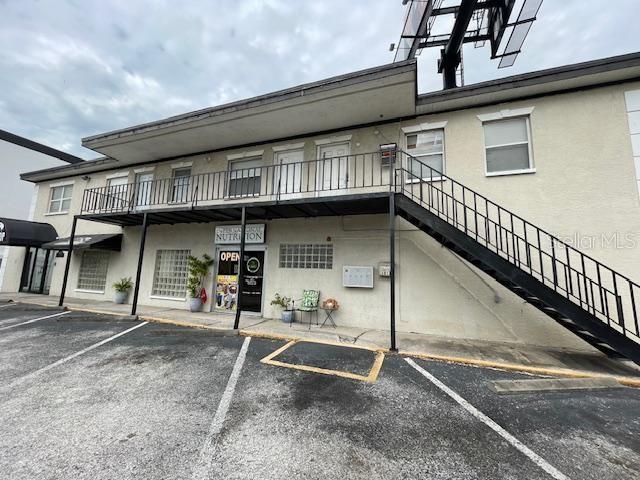 A two-story commercial building features an exterior metal staircase leading to an upper-level balcony — 4101 W CYPRESS STREET UNIT 201, TAMPA, FL