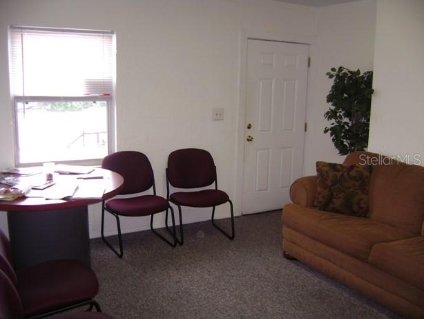A waiting room features a round table, two chairs, a brown sofa, and a door — 4101 W CYPRESS STREET UNIT 201, TAMPA, FL