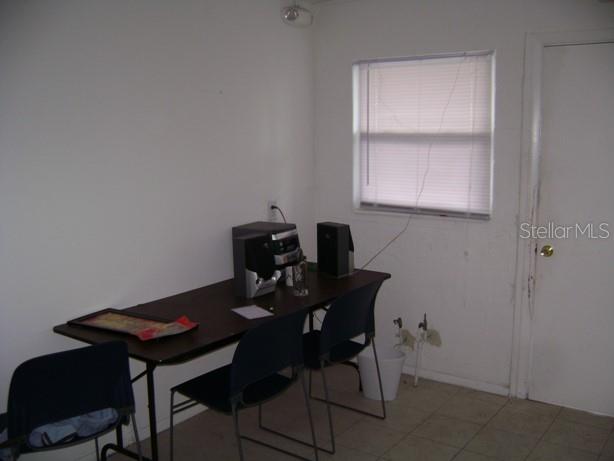 A room with a folding table, three chairs, a window with blinds, and tiled flooring — 4101 W CYPRESS STREET UNIT 201, TAMPA, FL