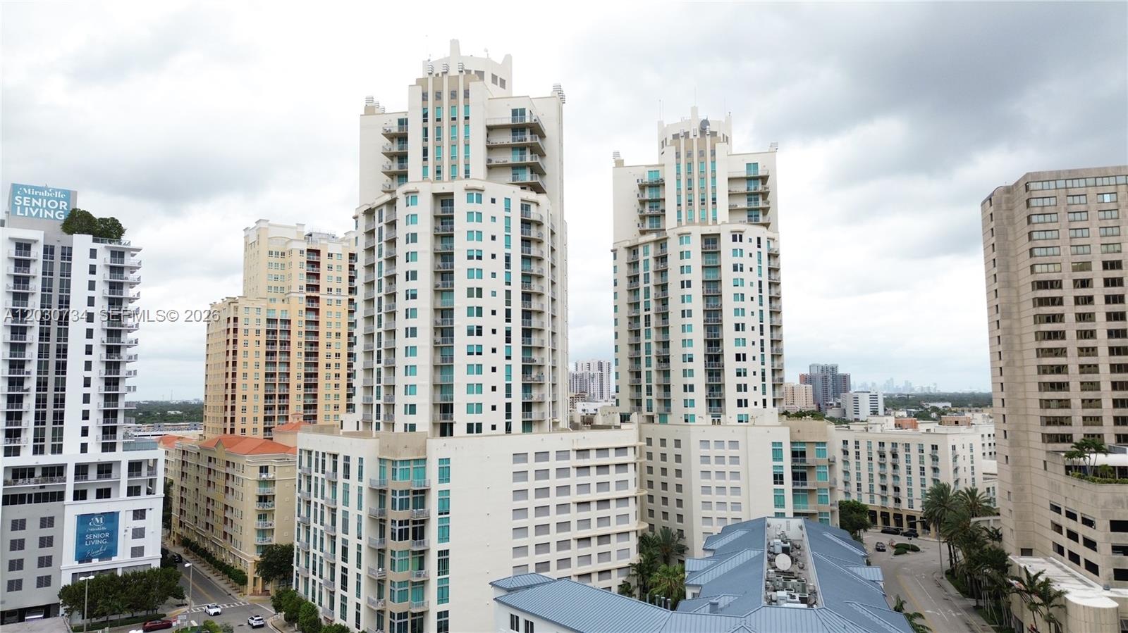 An exterior view shows several tall, modern apartment buildings under a cloudy sky — 9055 SW 73rd Ct # 1504, Miami FL 33156, MIAMI, FL