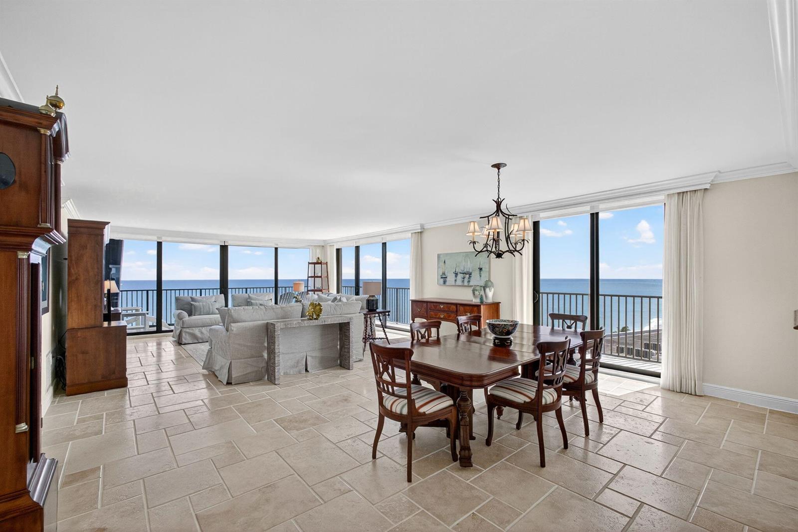 A spacious dining and living area features tile floors, a chandelier, and ocean views — 400 Beach Road # 804, Tequesta FL 33469, TEQUESTA, FL