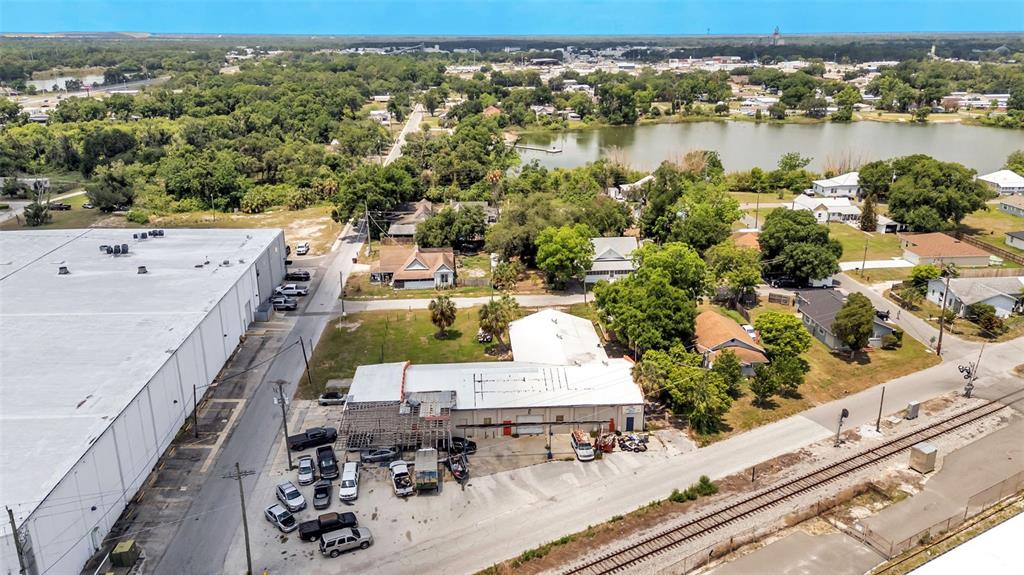 An aerial view shows a commercial building with a parking lot next to railroad tracks — 400 NW PHOSPHATE BOULEVARD, MULBERRY, FL