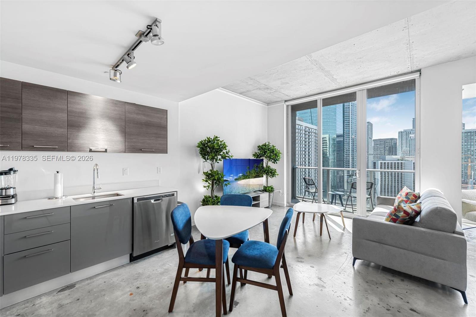 A modern studio apartment features a kitchen, dining area, and living space with city views — 151 SE 1st St # 2409, Miami FL 33131, MIAMI, FL
