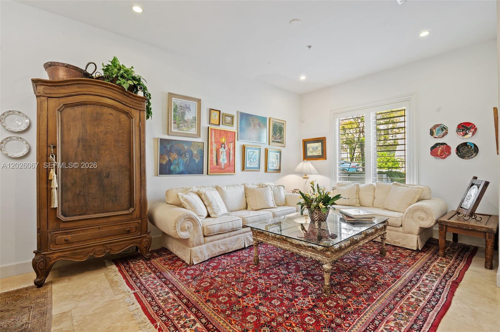 A living room features a large wooden armoire, a cream sofa, and a patterned rug — 7510 SW 56th Ct, Miami FL 33143, MIAMI, FL