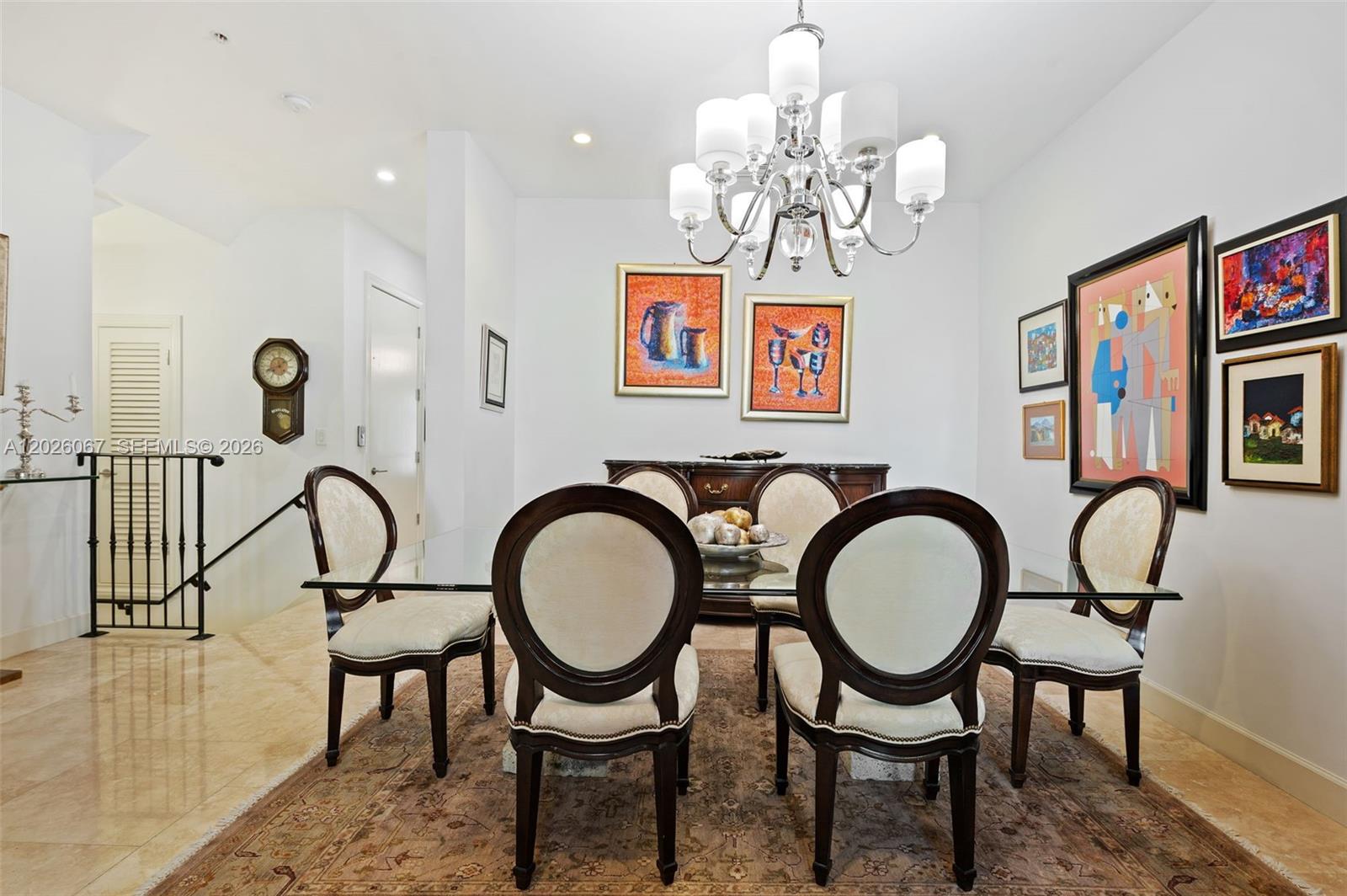 A dining room features a glass table, six upholstered chairs, a chandelier, and wall art — 7510 SW 56th Ct, Miami FL 33143, MIAMI, FL