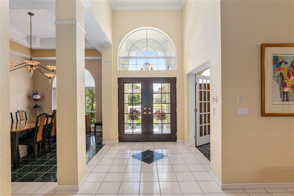 A bright foyer features white tile flooring, a double front door, and a dining area — 2215 SE SPRING HILL COURT, OCALA, FL