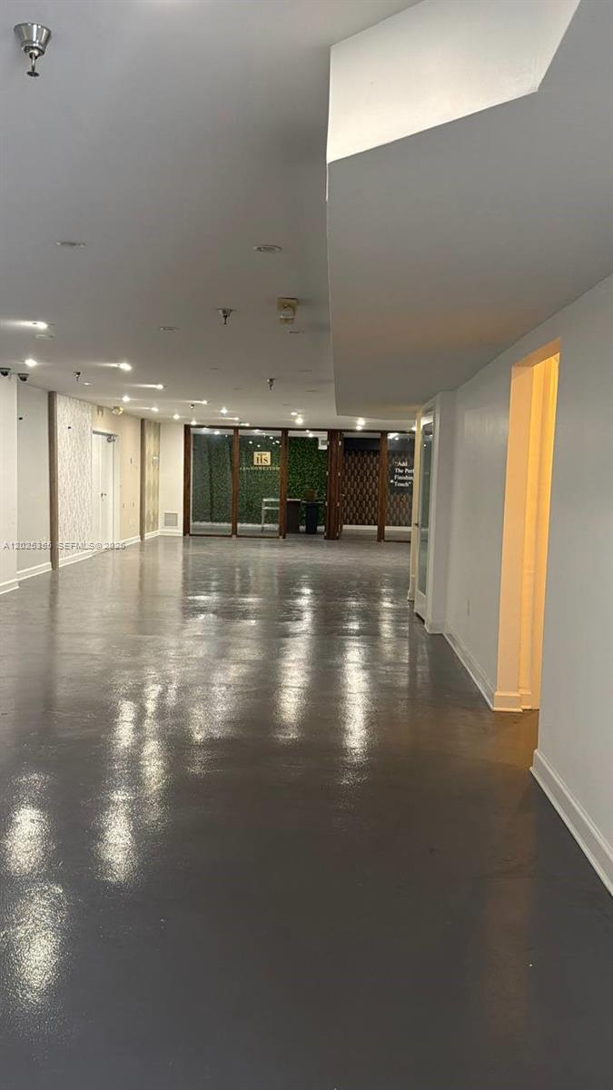 An empty, long room features a glossy gray floor and recessed ceiling lighting — 3002 NW 79th Ave # 3002, Doral FL 33122, DORAL, FL