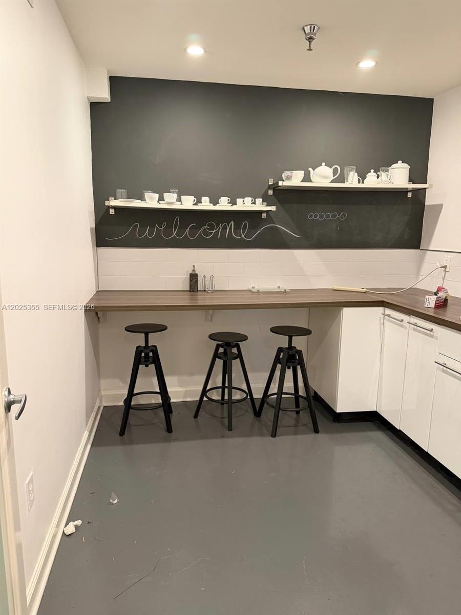 A kitchen features a breakfast bar with three stools, white cabinets, and a chalkboard wall — 3002 NW 79th Ave # 3002, Doral FL 33122, DORAL, FL