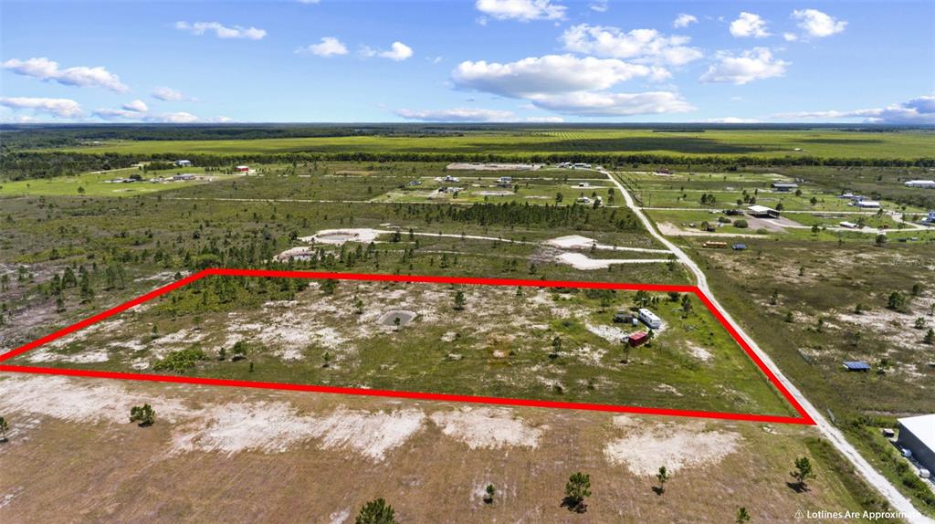 An aerial view shows a rectangular plot of land outlined in red with a small trailer — 49021 BERMONT ROAD, PUNTA GORDA, FL