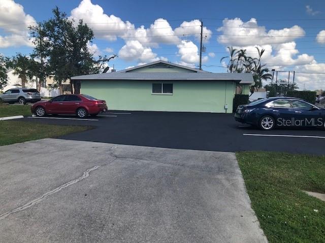 A light green building with a parking lot and three cars in front — 795 CRESTVIEW CIRCLE NW, PORT CHARLOTTE, FL