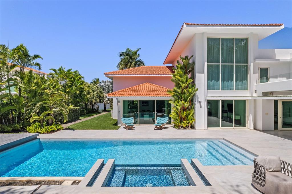 A modern house with a pink exterior, tiled roof, swimming pool, and a small hot tub — 336 DORADO BEACH EAST, DORADO, PR